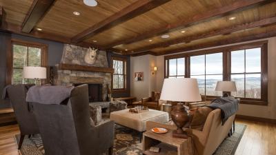 Exquisite living room with large stone fireplace and scenic window view of vacation rental in Mad River Valley Vermont