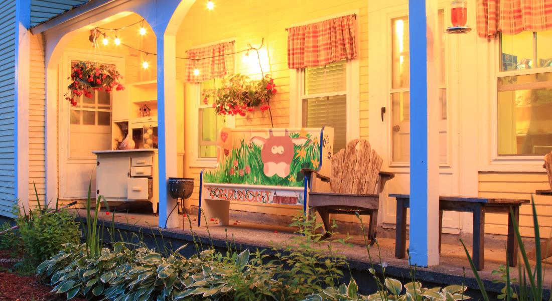 Warm lighting brightens a cozy, porch sitting area in the Mad River Valley Vermont