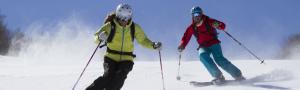 Skiers enjoy turns under the sun and blue skies of the Mad River Valley Vermont